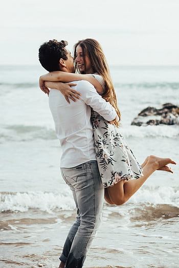 Happy couple in love embracing on a sandy beach by the ocean. HD phone wallpaper
