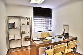 Sleek and contemporary office space featuring a wooden desk, chairs, and organized shelves. HD wallpaper