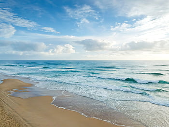 Serene view of gentle waves and sandy shore at Castaways Beach, QLD, Australia. HD wallpaper