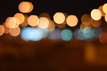 Captivating abstract bokeh lights in warm colors against a dark night background. HD wallpaper