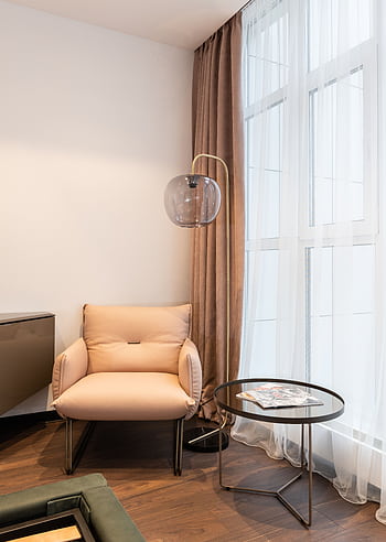 Cozy armchair and side table in a stylishly designed living room. Perfect for relaxation. HD phone wallpaper