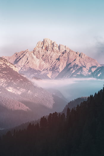Breathtaking mountain scenery at sunrise with mist and vibrant colors, perfect for nature lovers. HD phone wallpaper