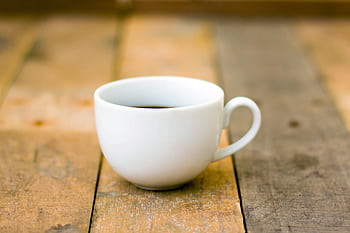 Simple white cup of coffee on rustic wooden table, perfect for a cozy morning HD wallpaper