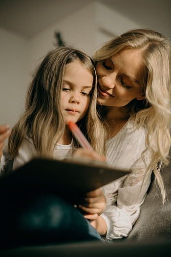 A loving mother and daughter bonding through art in a cozy setting. HD phone wallpaper