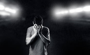 Black and white of a man covering his face, conveying emotion and solitude. HD wallpaper