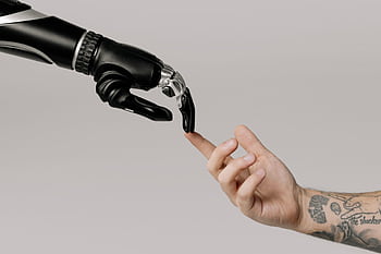 A human hand with tattoos reaching out to a robotic hand on a white background. HD wallpaper