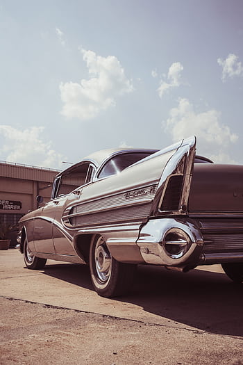 Classic Buick Roadmaster captured on a sunny day showcasing its vintage tail fins and chrome details. HD phone wallpaper