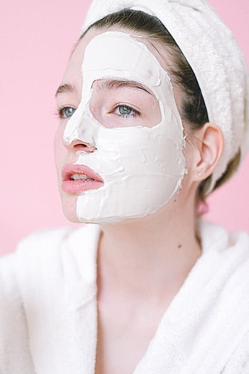 Young woman with a skincare mask and towel in a calm spa setting. HD phone wallpaper