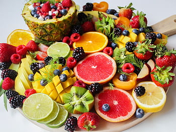 A vibrant assortment of fresh fruits beautifully arranged on a platter, perfect for a healthy and delicious snack. HD wallpaper