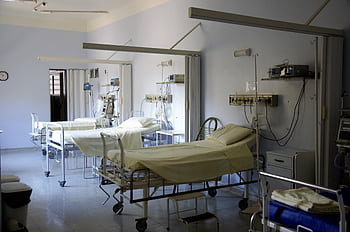 Spacious hospital room with several empty beds and medical equipment, emphasizing healthcare and hygiene. HD wallpaper
