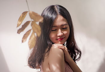 Peaceful young woman with eyes closed, embracing serenity with a gentle smile. HD wallpaper