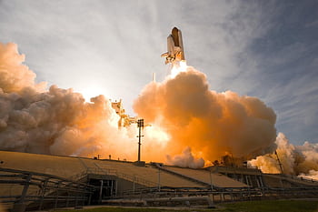 Dramatic view of a space shuttle launching, surrounded by smoke and fire. HD wallpaper