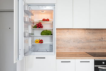 Open fridge in a sleek kitchen with fresh vegetables, perfect for healthy meals. HD wallpaper