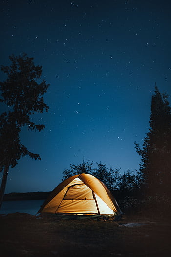 A serene campsite under a starry sky in Ely, Minnesota. Perfect outdoor adventure setting. HD phone wallpaper