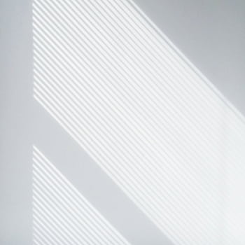 Soft natural light casting geometric shadows on a white wall, creating a minimalist aesthetic. HD wallpaper