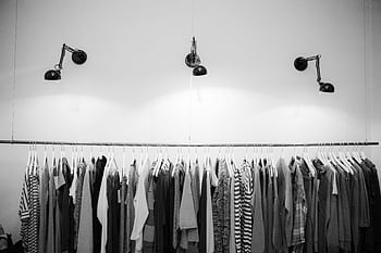 Minimalist black and white clothing display in a stylish boutique setting. HD wallpaper