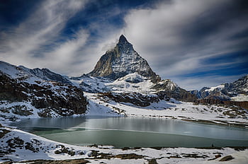 Scenic winter view of the Matterhorn mountain with a lake, perfect for adventure and travel ry. HD wallpaper