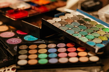 A vibrant close-up of assorted makeup palettes showcasing diverse colors and textures. HD wallpaper