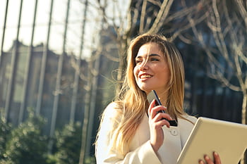 Smiling businesswoman holding smart and tablet outdoors in Milan. HD wallpaper