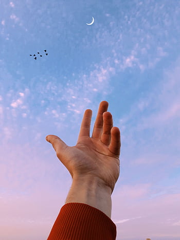 A hand reaching towards the crescent moon against a pastel sky, symbolizing aspiration. HD phone wallpaper