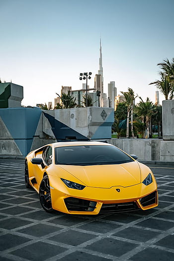 Stunning yellow Lamborghini parked with the Burj Khalifa in the background during the day. HD phone wallpaper