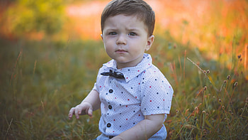 Cute Baby Boy Is Sitting On Grass In Blur Background Wearing White Dress Cute HD wallpaper