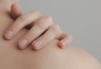 A gentle close-up of a hand resting on a person's shoulder, emphasizing skin texture. HD wallpaper