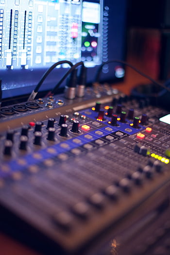 Close-up of a professional audio mixing console with glowing LED indicators. HD phone wallpaper