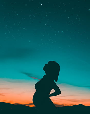 A beautiful silhouette of a pregnant woman under a starry sky during sunset, capturing tranquility and anticipation. HD phone wallpaper