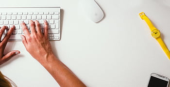 Close-up of hands typing on a keyboard with a yellow watch on the desk HD wallpaper