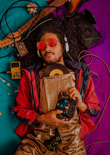 Man with afro and heads enjoying retro music surrounded by vintage items. HD phone wallpaper