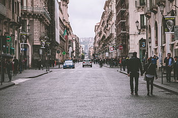 A bustling European street scene with architecture and a couple holding hands. HD wallpaper