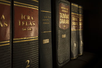 Detailed close-up of law and regulation books on a bookshelf, emphasizing education and knowledge. HD wallpaper