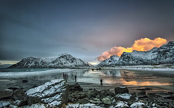 Sunset reflects over snowy mountains and coastline in Flakstad, Norway, creating a breathtaking scene. HD wallpaper