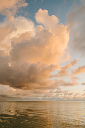 Serene ocean view with dramatic clouds and golden sunset, capturing harmony and natural beauty. HD phone wallpaper