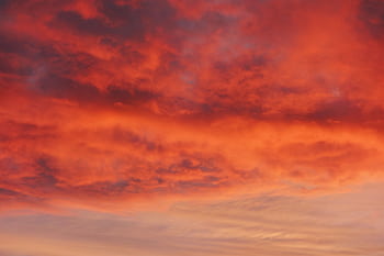 A stunning sunset sky filled with vibrant red and orange clouds, capturing nature's beauty. HD wallpaper