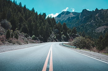 Winding road through lush forests and mountains in Bariloche, Argentina. HD wallpaper