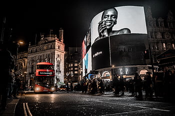 Vibrant city life at night in Piccadilly Circus, London with double-decker bus and illuminated billboards. HD wallpaper