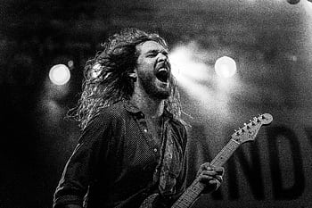Expressive guitarist passionately performing live on stage in black and white. HD wallpaper
