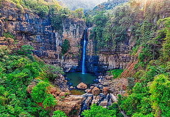 A breathtaking aerial view of a lush forest waterfall in West Java, Indonesia. HD wallpaper
