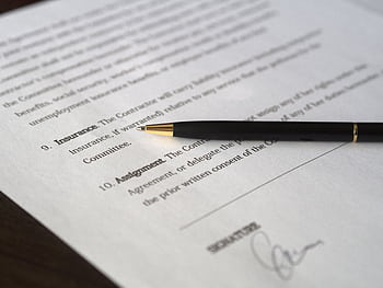 Close-up of a business contract and pen, signed and ready for agreement. HD wallpaper