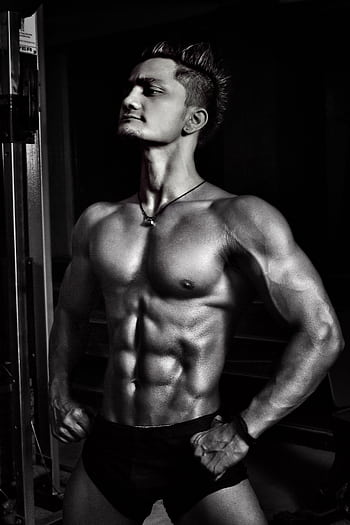 Dynamic black and white of a muscular male bodybuilder striking a powerful pose. HD phone wallpaper