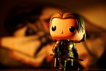 A cute toy figure in armor with dramatic light and warm tones, perfect for creative projects. HD wallpaper