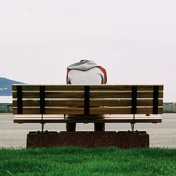A person sitting alone on a bench, capturing solitude and contemplation by the riverside. HD phone wallpaper