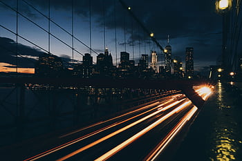 Stunning urban night scene with light trails on bridge and city skyline. HD wallpaper