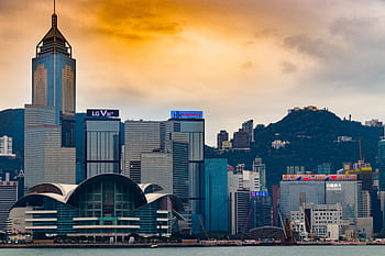 Captivating view of Hong Kong's modern skyline against a vibrant sunset, showcasing iconic skyscrapers. HD wallpaper