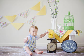 Charming baby enjoying a playful Easter scene with decorations inside. HD wallpaper