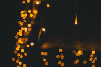 Enchanting warm bokeh effect of festive string lights on a dark background. HD wallpaper