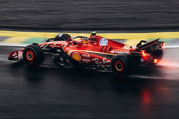 High-speed Formula 1 car racing on wet track showcasing power and precision. HD wallpaper