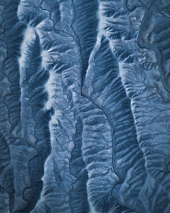 Stunning aerial shot of winter mountains showcasing icy ridges and patterns. HD phone wallpaper